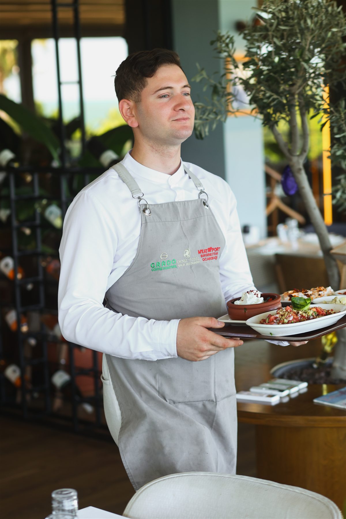 Meze tabaklarını masaya taşıyan servis görevlisi